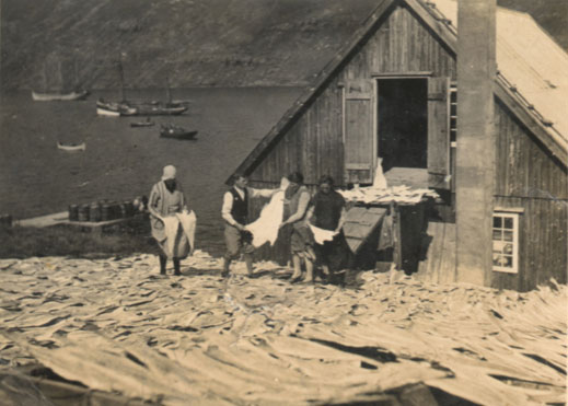 Tíðarmynd: Fiskaarbeiðið á "Løðustøðinum" við Løðupakkhúsið, Sørvági, uml. 1935. T.v. Norðistovubrúgvin. Á vánni: trýmastra skonnart, slupp, deksbátur og smábátar. 